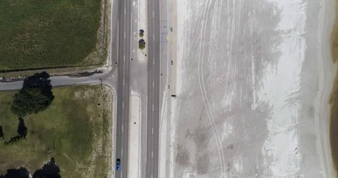 High tracking shot directly over cyclist riding along beach drone aerial 4K Stock Footage 111365014