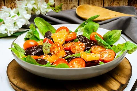 High view of exquisite salad of beetroot, orange, cherry tomato and arugula w Stock Photos