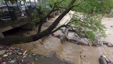 High view of muddy flood water flowing under urban bridge a high-angle view Vídeos de archivo 342585818