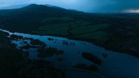 High view over a mountain dam with small islands of forest before sunrise Stock Photos