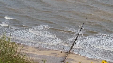 High up view over the sandy beach. Captured from the cliff tops above Video stock 308190759