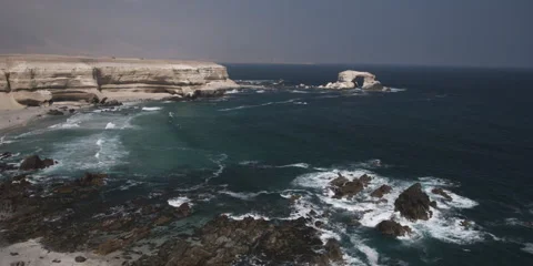 High view of a rugged coast near a bare headland and arched sea stack Stock Footage 59185746