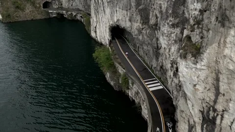 High view, runner runs to the road close to lake. Video 4K Video stock 321281970