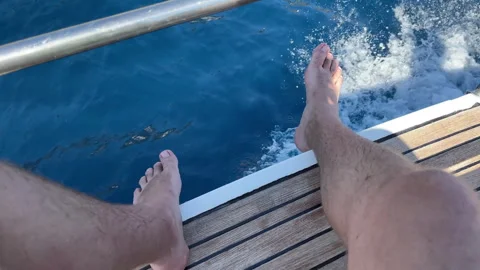 High view shot of persons legs sitting on deck of sailing motorboat, amazing 스톡 동영상 316894430