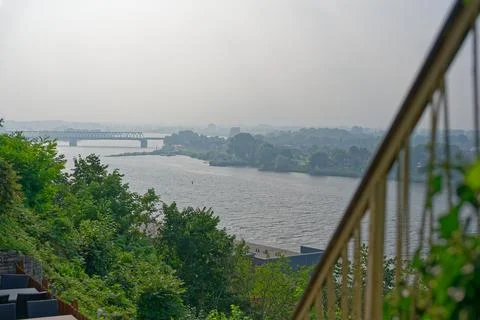 High viewpoint over water and bridge with treetops and railing in frame in .. Stock Photos