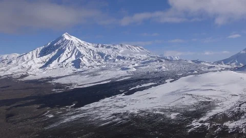 High volcano covered with white snow at grey frozen lava Stock Footage 116600579