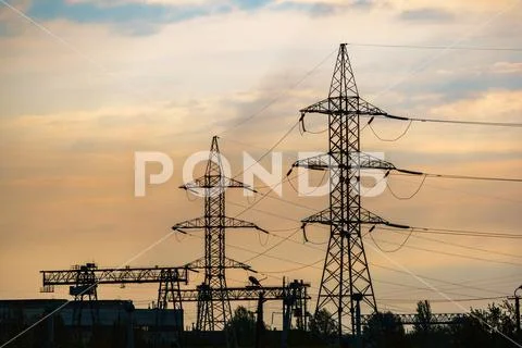 High voltage cable power post steel tower pylons in sunset Stock Photos