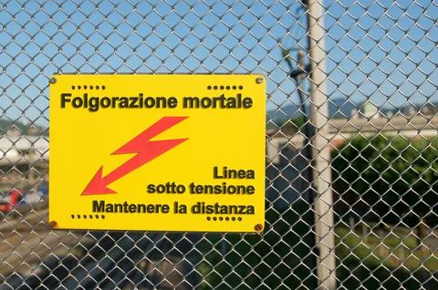 High voltage danger sign warning of fatal electrocution on railway fence in.. Stock Photos