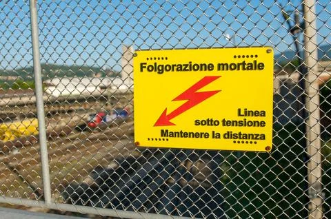 High voltage danger sign warning of fatal electrocution on railway fence in.. Stock Photos