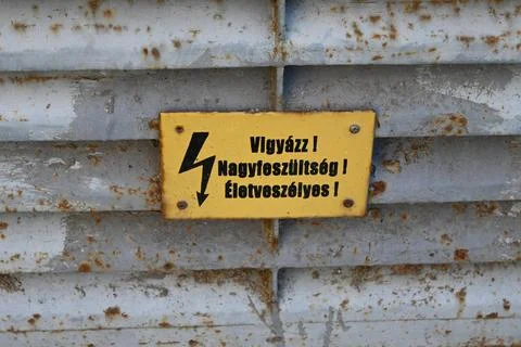 High voltage danger warning sign on rusty metal wall 스톡 사진