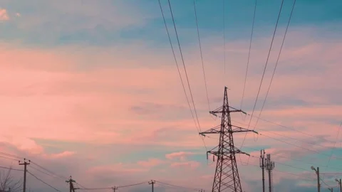 High-Voltage Electric Pole and Time Lapse of Orange Peach Clouds and Blue Sunset Stock-Footage 324497642