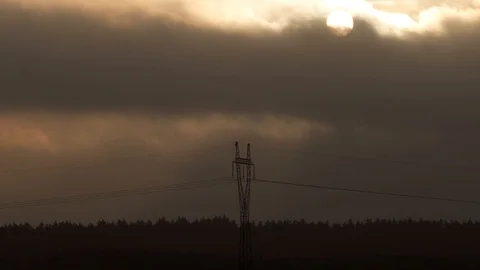 High voltage electric pole in menacing cloudscape with the sun Stock Footage 124458843