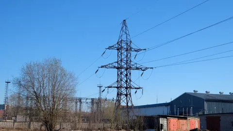 High voltage electric tower on sunny sky background in spring village. Stock Footage 276739005