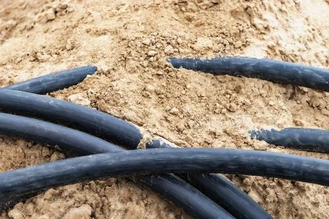 The high voltage electrical cable is laid in a trench. Close-up 스톡 사진