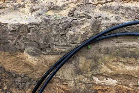 The high voltage electrical cable is laid in a trench under existing engineer Stockfoto's