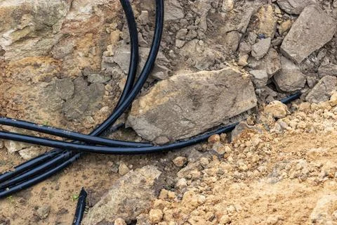 The high voltage electrical cable is laid in a trench under existing engineer Stock-Fotos