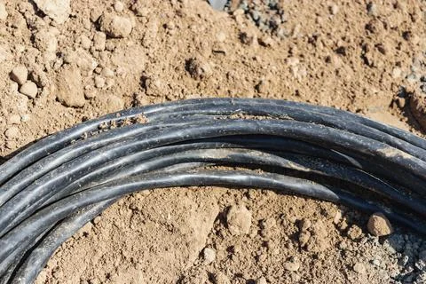The high voltage electrical cable is laid in a trench. Close-up of an electri Photos