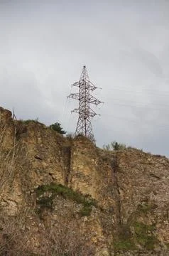 High-Voltage Electrical Pylon Situated on a Steep Rocky Ridge Fotos de archivo
