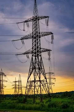 High voltage electrical pylon tower against colorful sunset sky Stock Photos