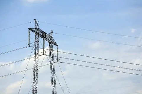 High voltage electrical pylon towering against a picturesque clear blue Stock Photos