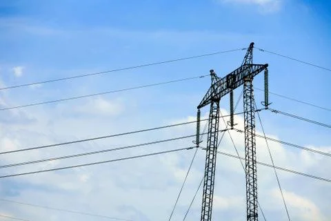 High voltage electrical pylon towering against a picturesque clear blue Stock Photos