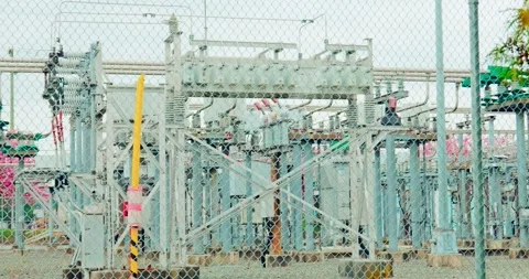 High voltage electrical substation behind security chain link fence Stock Footage 333223926