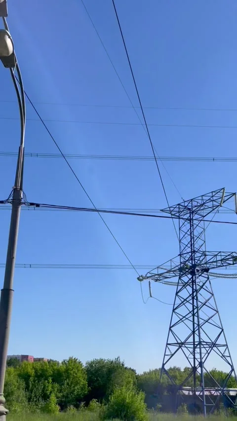 High voltage electrical tower against blue sky. Transmission line transporting Stock Footage 339434051