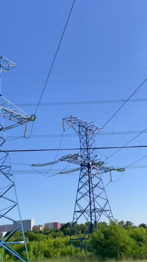 High voltage electrical tower with transmission lines against clear blue sky. Stock Footage 339432209