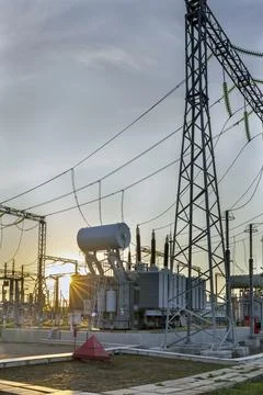 High voltage electrical transformer at sunset. Stock Photos