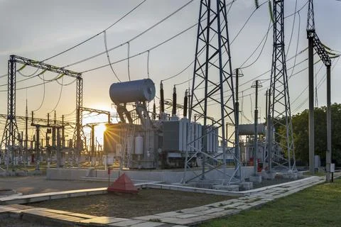 High voltage electrical transformer at sunset. Stock Photos