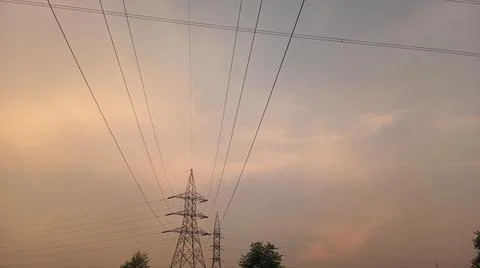 High-voltage electrical transmission tower during twilight or sunset 스톡 사진