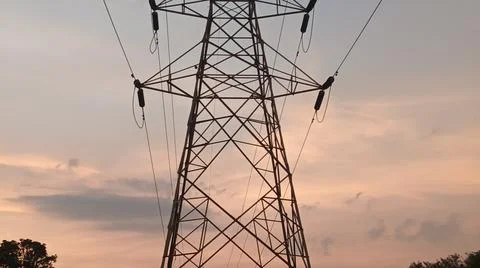 High-voltage electrical transmission tower during twilight or sunset Foto stock