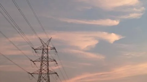 High-voltage electrical transmission tower during twilight or sunset Stock-Fotos