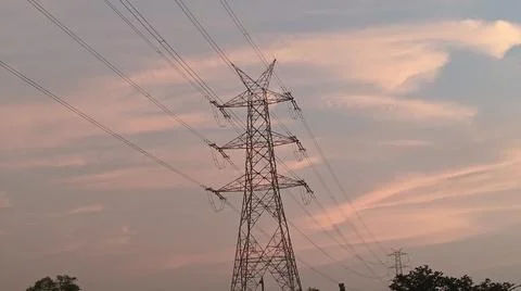 High-voltage electrical transmission tower during twilight or sunset Stock Photos
