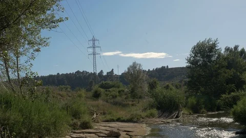 High voltage field countryside tower electricity modern river stream water Stock Footage 113112895