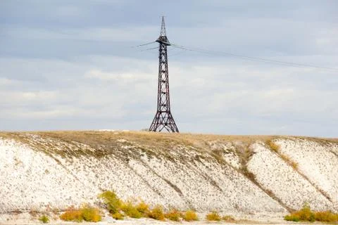 High voltage line and electricity pylon on coastline of river. Stock Photos