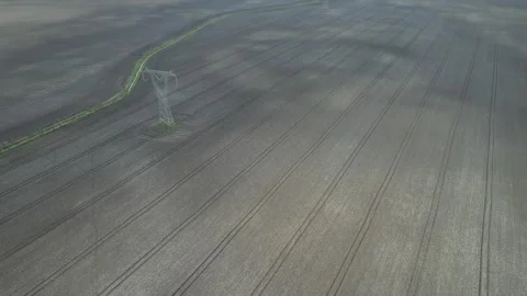High voltage line with poles over a plowed field - aerial drone view Stock Footage 271297862