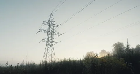 High voltage lines and power pylons in a flat and green agricultural landscape Stock Footage 138991751