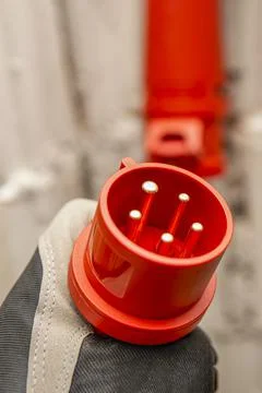High voltage plug in hand. Connecting a 380 volt high voltage, three phase plug Stock Photos