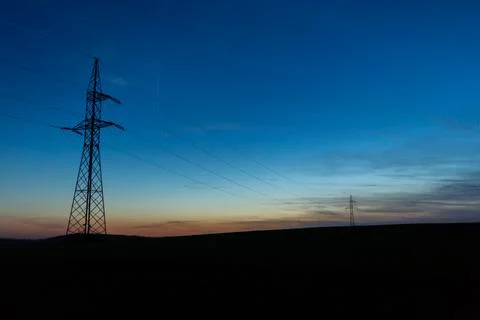 High voltage poles standing on the background of the blue hour Stock Photos