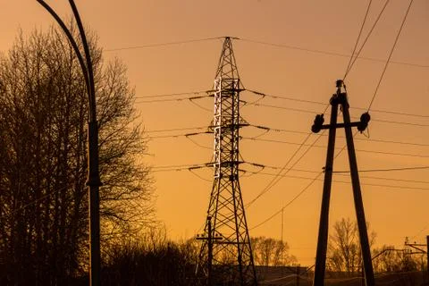 High-voltage poles of two intersecting power lines of different voltage again Stock Photos