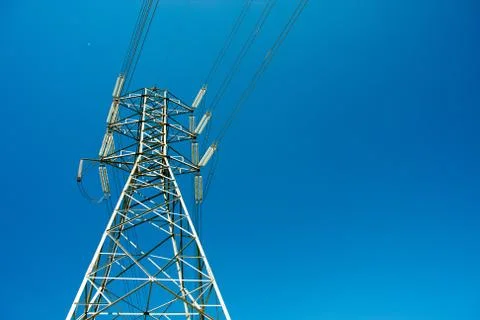 High voltage post against clear blue sky background Stock Photos