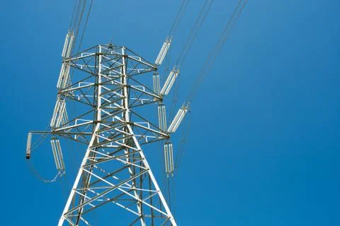 High voltage post against clear blue sky background Stock Photos