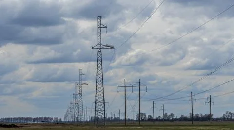 High voltage post on blue sky with clouds background. Electrical net of poles Stock Photos