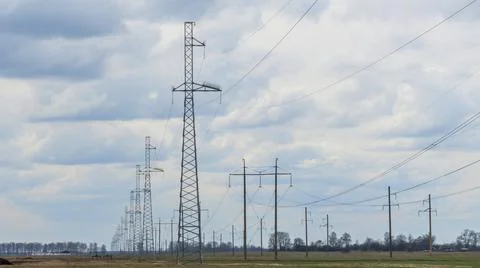 High voltage post on blue sky with clouds background. Electrical net of poles Stock Photos