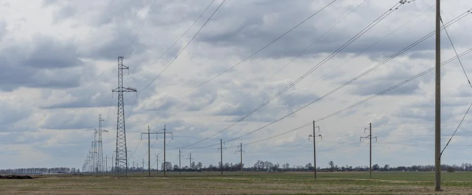 High voltage post on blue sky with clouds background. Electrical net of poles Stock Photos
