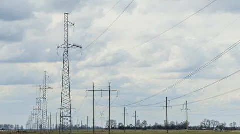 High voltage post on blue sky with clouds background. Electrical net of poles Stock Photos