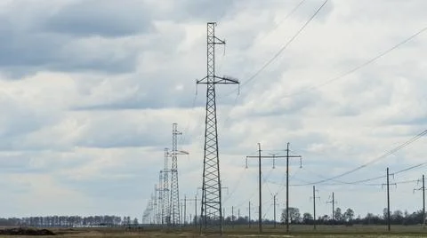 High voltage post on blue sky with clouds background. Electrical net of poles Stock Photos