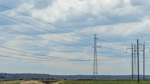 High voltage post on blue sky with clouds background. Electrical net of poles Stock Photos