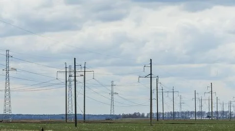 High voltage post on blue sky with clouds background. Electrical net of poles Stock Photos